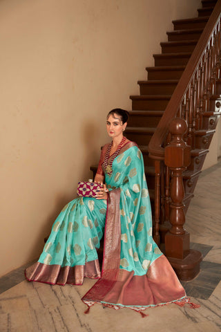 TURQUOISE LINEN BOTANICAL BUTTA SAREE WITH ETHNIC MOTIF GOLDEN ZARI RED PALLU AND TASSEL IN BORDER